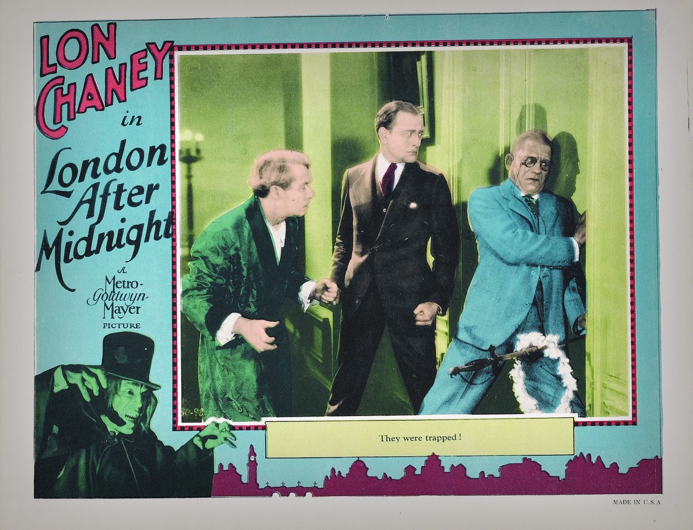 Colour lobby card for London After Midnight: Lon Chaney holds a lantern beside two frightened figures, with the caption 'A prisoner in the House of Mystery'